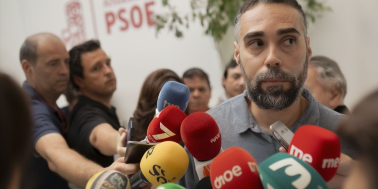 Rubén Sánchez rodeado de medios de comunicación y de micrófonos frente a una sede del PSOE en una comparecencia pública.