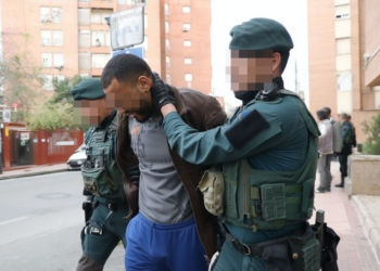 Agentes de la Guardia Civil deteniendo a un hombre en la vía pública en un entorno urbano.