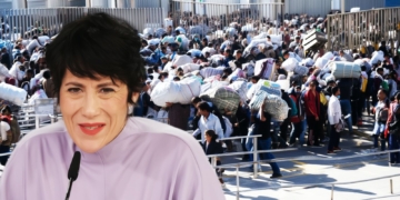 Montaje con Elma Saiz hablando en un micrófono en primer plano y, de fondo, una gran multitud de personas inmigrantes cargando bultos en una zona fronteriza.
