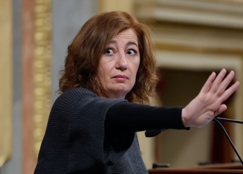 Francina Armengol en el Congreso de los Diputados levanta la mano en gesto de detener o pedir silencio, con expresión seria mientras habla frente a un micrófono.