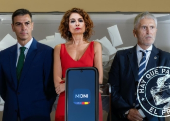 Pedro Sánchez, Maria Jesús Montero y Fernando Grande-Marlaska frente a una urna electoral con papeletas al fondo y un dispositivo móvil en primer plano.