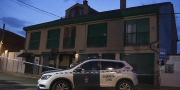 Vehículo de la Guardia Civil frente a una vivienda acordonada con cinta policial