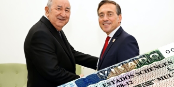 Vicente Moreno Sanchís y José Manuel Albares se saludan mientras aparece un visado Schengen en primer plano.