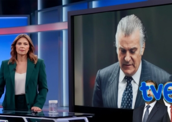 Presentadora en un plató de televisión junto a una pantalla donde aparece Bárcenas trajeado