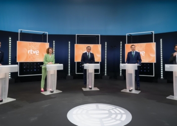Debate en Andalucía con los cinco participantes en un debate político, cada uno en su atril dentro de un plató de televisión