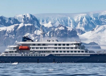 Crucero de expedición navegando frente a montañas cubiertas de nieve en un entorno polar en el contexto de el hantavirus en un crucero rumbo a Canarias
