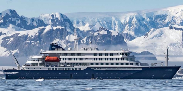 Crucero de expedición navegando frente a montañas cubiertas de nieve en un entorno polar en el contexto de el hantavirus en un crucero rumbo a Canarias
