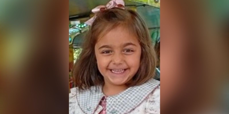 ¿Dónde está Miranda? Niña pequeña sonriente con lazo en el cabello, en lo que parece un entorno de juego o parque