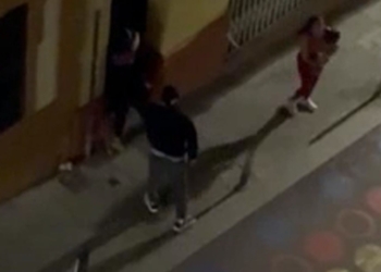 Imagen nocturna de varias personas en una acera captada desde una cámara de vigilancia o gran altura en España