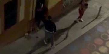 Imagen nocturna de varias personas en una acera captada desde una cámara de vigilancia o gran altura en España