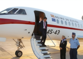 Sánchez desciende de un avión oficial del Reino de España mientras saluda desde la escalerilla.