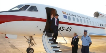 Sánchez desciende de un avión oficial del Reino de España mientras saluda desde la escalerilla.