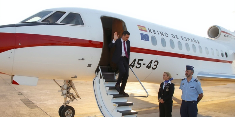 Sánchez desciende de un avión oficial del Reino de España mientras saluda desde la escalerilla.