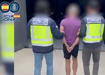 Cambio de género: Dos agentes de la Policía Nacional escoltan a una persona detenida con las manos esposadas detrás de la espalda.