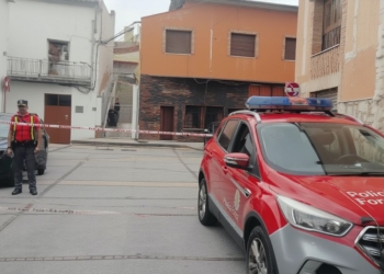 Navarra: magrebí confiesa el asesinato de su mujer . Calle acordonada por la policía con un vehículo de la Policía Foral estacionado frente a varios edificios residenciales.