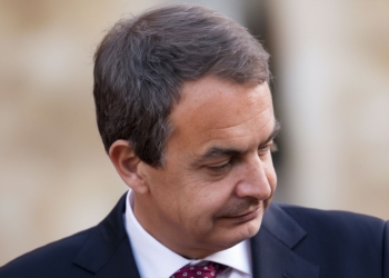 Las incógnitas del Caso Zapatero. Retrato de José Luis Rodríguez Zapatero mirando hacia abajo con expresión seria.