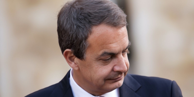 Las incógnitas del Caso Zapatero. Retrato de José Luis Rodríguez Zapatero mirando hacia abajo con expresión seria.