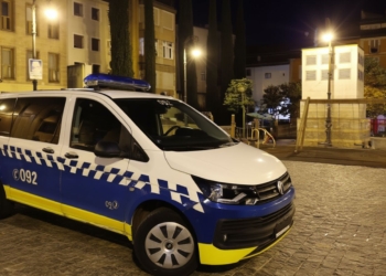 Ilegal marroquí a juicio por abuso a 2 menores en Pamplona. Furgoneta policial estacionada de noche en una plaza urbana iluminada.