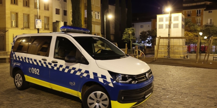 Ilegal marroquí a juicio por abuso a 2 menores en Pamplona. Furgoneta policial estacionada de noche en una plaza urbana iluminada.