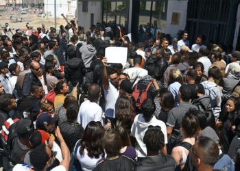 Mafias y ayuntamientos: el negocio de los padrones falsos. Gran grupo de personas concentradas frente a la entrada de un edificio.