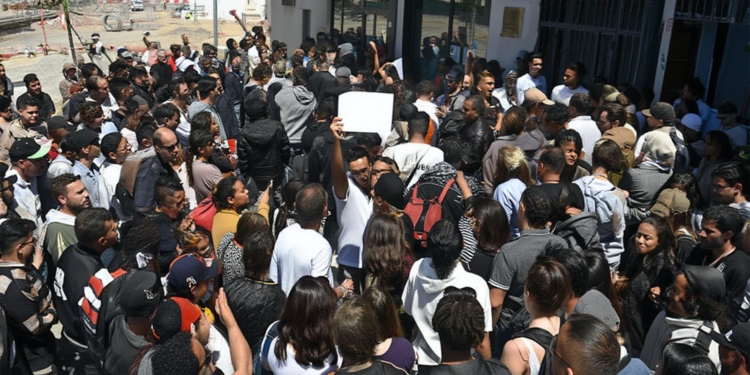 Mafias y ayuntamientos: el negocio de los padrones falsos. Gran grupo de personas concentradas frente a la entrada de un edificio.