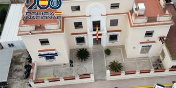 Dénia: marroquí detenido por violar a menor autista. Vista aérea de un edificio de la Policía Nacional con bandera de España en la entrada.