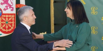 La UCO también registra la sede de la Dirección de la Guardia Civil. Imagen de Marlaska y una mujer se saludan frente a banderas y emblemas institucionales.