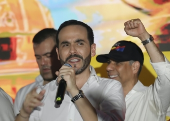 El comunista Gustavo Petro no reconoce su derrota. Abelardo de la Espriella habla con un micrófono ante varias personas mientras otra levanta el puño en un acto público.
