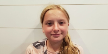 Francia obliga a sus ciudadanos a pagar el asesinato de Lola por una inmigrante ilegal. Imagen de la niña asesinada Lola Daviet con abello rubio recogido mira a la cámara con una leve sonrisa frente a una pared clara.