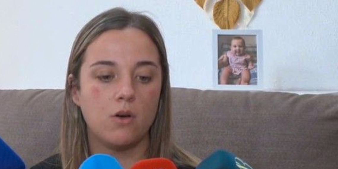 La madre de la bebé de 16 meses fallecida sospecha de que su pareja la quemó «por celos». Mamá del bebe sentada en un sofá mientras atiende a varios micrófonos durante una entrevista.