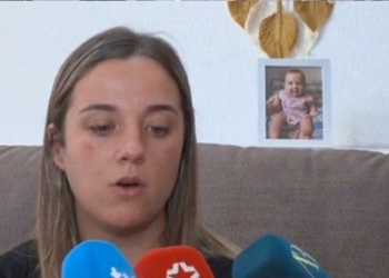 La madre de la bebé de 16 meses fallecida sospecha de que su pareja la quemó «por celos». Mamá del bebe sentada en un sofá mientras atiende a varios micrófonos durante una entrevista.
