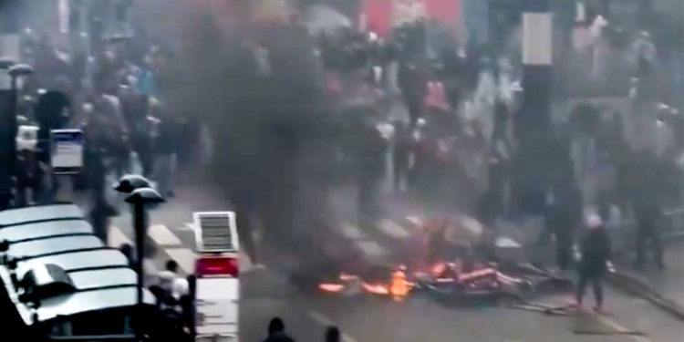 Bruselas: la ultraizquierda y los inmigrantes destrozan el corazón de Europa. Disturbios en Bruselas con barricadas en llamas y denso humo en una calle urbana.
