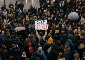 11 sucesos de hoy: fin de la seguridad en España y Europa. Gran multitud de jóvenes reunidos en una protesta pacífica en la calle, con un cartel que dice “STOP VIOLENCE”