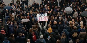 11 sucesos de hoy: fin de la seguridad en España y Europa. Gran multitud de jóvenes reunidos en una protesta pacífica en la calle, con un cartel que dice “STOP VIOLENCE”