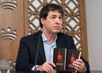 El "hermanísimo" oye campanas y eso le convirtió en director. David Sánchez, hermano de Pedro Sánchez, sosteniendo dos ejemplares del libro “CARMEN” durante un acto público.