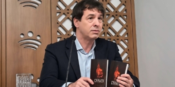 El "hermanísimo" oye campanas y eso le convirtió en director. David Sánchez, hermano de Pedro Sánchez, sosteniendo dos ejemplares del libro “CARMEN” durante un acto público.