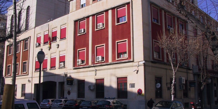 Jaén: Docente detenida por presunta relación con un menor de 15 años. Edificio de la Policía Nacional en España, con varios vehículos policiales aparcados en la entrada.