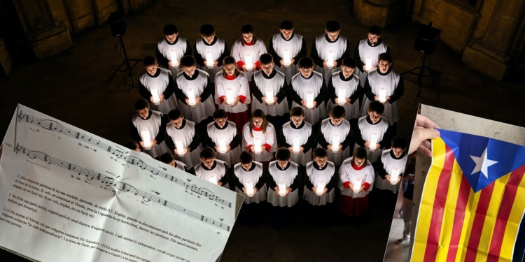 Intento de boicot independentista: expulsados 600 cantantes por querer imponer "Els Segadors" y esteladas en la Sagrada Familia. Coro cantando con velas en un templo, con partitura musical en catalán y una bandera estelada superpuesta.