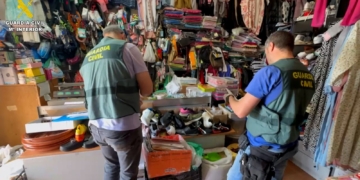 ¡Red criminal desmantelada! Cobraban 10.500€ por falsificar la regularización de inmigrantes ilegales. Agentes de la Guardia Civil registrando un establecimiento comercial repleto de mercancía.