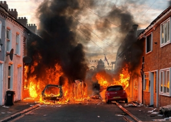 Belfast: vídeo de la caza casa por casa de solicitantes de asilo. Calle residencial en llamas con varios vehículos ardiendo y denso humo negro durante un disturbio.