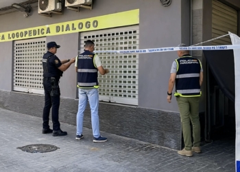 Padre desesperado mata a puñaladas al logopeda de su hijo de 2 años en Valencia al descubrirlo semidesnudo. Agentes de la Policía Nacional realizando una operación frente a la Clínica Logopédica Diálogo, con cinta policial acordonando la zona.