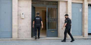 Hallazgo macabro en Castellón durante un operativo policial por delito de agresión sexual: un cadáver en la nevera. Dos agentes de la Policía Nacional entrando en un portal de un edificio en la calle donde ocurrieron los hechos.