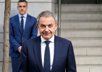 José Luis Rodríguez Zapatero no convence pese a la ayuda del juez y Sánchez mira ya a las vacaciones. José Luis Rodríguez Zapatero sonriendo frente a un edificio institucional.