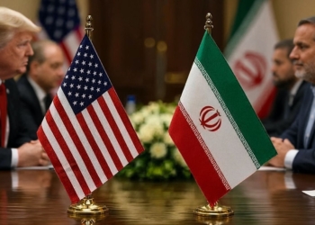 Trump y su declive tras el pacto de 14 puntos humillante ¿Fin de Trump?. Donald Trump y un representante iraní sentados en una mesa de negociaciones con las banderas de Estados Unidos e Irán.