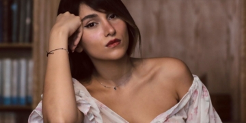 Parastoo Ahmadi condenada a 74 latigazos por Irán tras cantar sin velo en un concierto. Retrato de la cantante Parastoo Ahmadi apoyando la cabeza en la mano con expresión pensativa.
