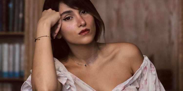 Parastoo Ahmadi condenada a 74 latigazos por Irán tras cantar sin velo en un concierto. Retrato de la cantante Parastoo Ahmadi apoyando la cabeza en la mano con expresión pensativa.