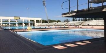 Son Hugo: Italiano se atrincheró en un vestuario de niñas para espiarlas mientras se duchaban. Piscina olímpica exterior de Son Hugo en Palma de Mallorca con gradas y cielo despejado.