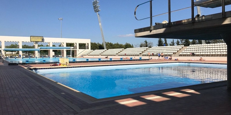 Son Hugo: Italiano se atrincheró en un vestuario de niñas para espiarlas mientras se duchaban. Piscina olímpica exterior de Son Hugo en Palma de Mallorca con gradas y cielo despejado.