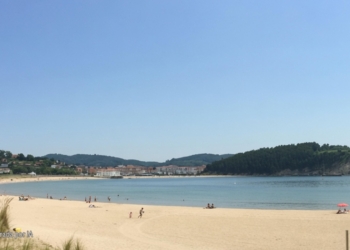 Policías acorralados por bandas en Plentzia: la calle ya no es nuestra. Playa de Plentzia con arena, mar y colinas al fondo, generada por inteligencia artificial.