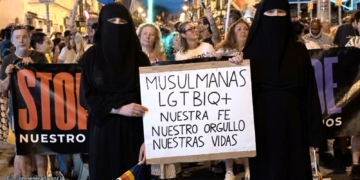El vídeo viral que humilló al Orgullo LGTBIQ+ de Sevilla. Dos mujeres con niqab sosteniendo un cartel en una manifestación LGTBIQ+, generado por IA.
